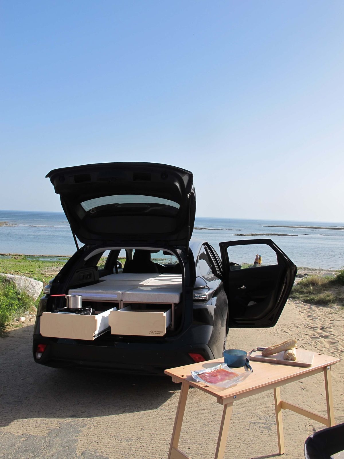Kit Easy Trip déployé en bivouac : table extérieure, tiroirs cuisine et couchage